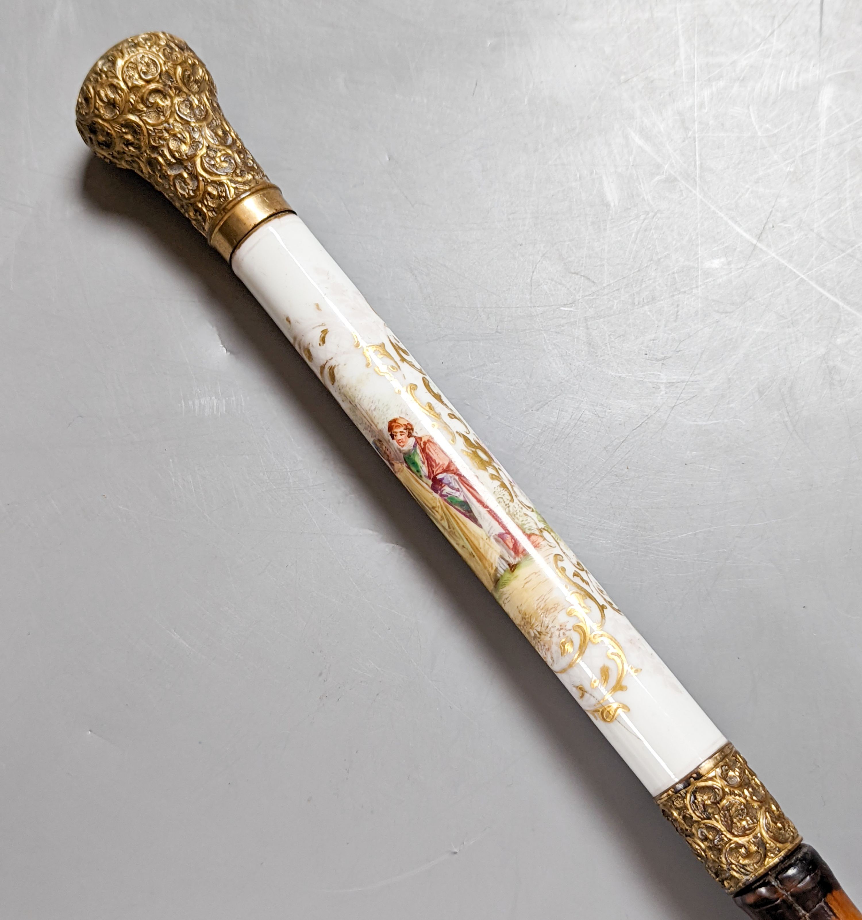 A porcelain mounted sword stick with gilt decoration to blade